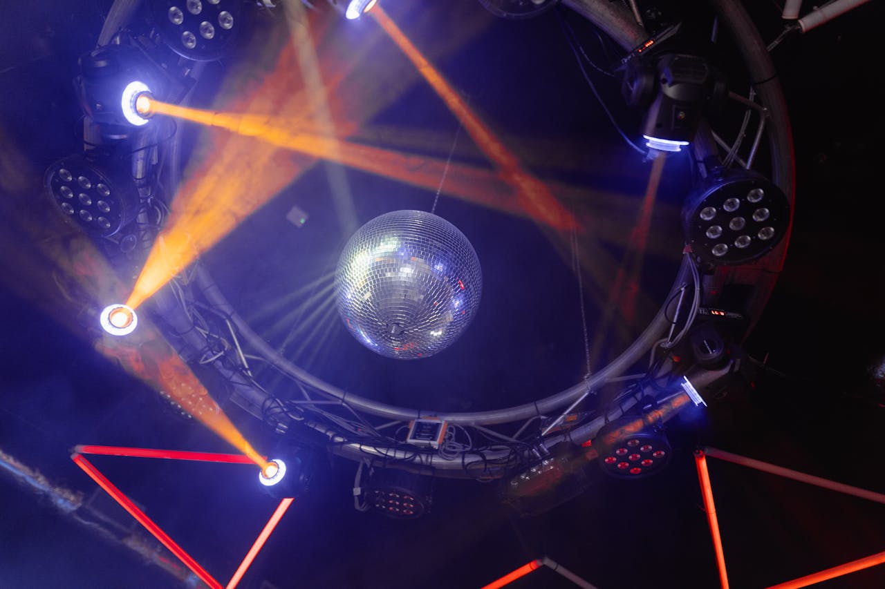 Vibrant nightclub scene with colorful lights and disco ball, creating a lively atmosphere.